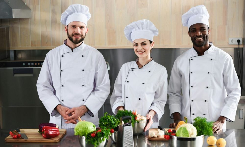 multiracial-chefs-team-smiling-by-modern-kitchen-counter.jpg